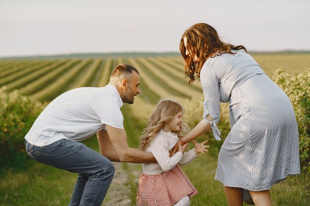 Famille avec petite fille, passer du temps ensemble dans un champ ensoleillé