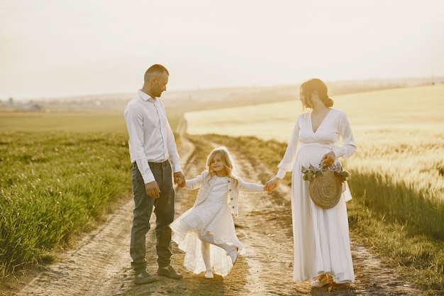 Famille avec petite fille, passer du temps ensemble dans un champ ensoleillé