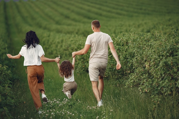 Famille avec petite fille, passer du temps ensemble dans un champ ensoleillé