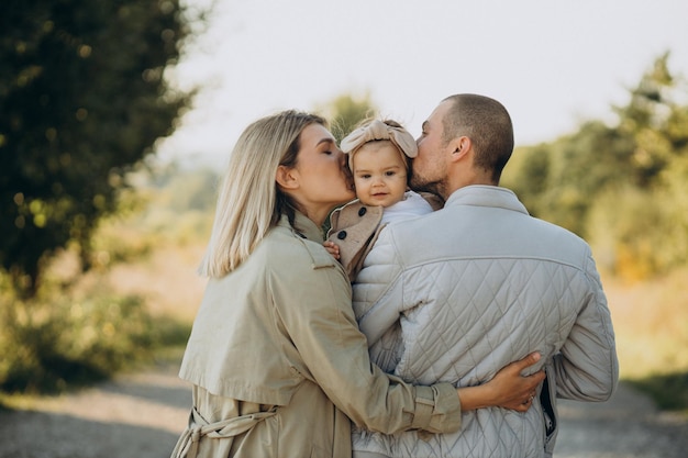 Famille avec petite fille passer du temps ensemble dans un champ ensoleillé