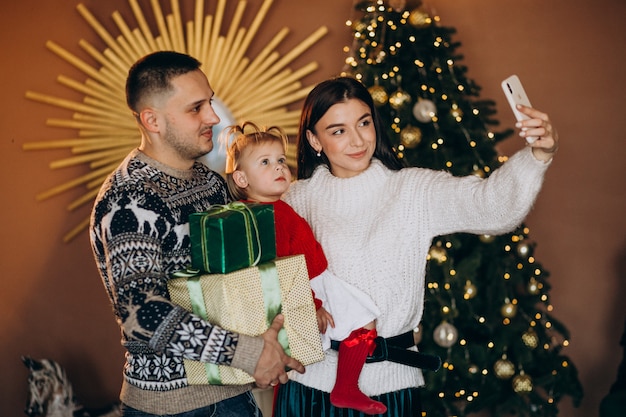 Photo gratuite famille avec petite fille près de boîte de cadeau de déballage d'arbre de noël