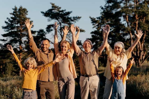 Photo gratuite famille de plan moyen avec les mains en l'air