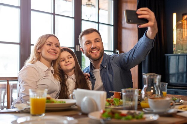 Famille de plan moyen prenant selfie