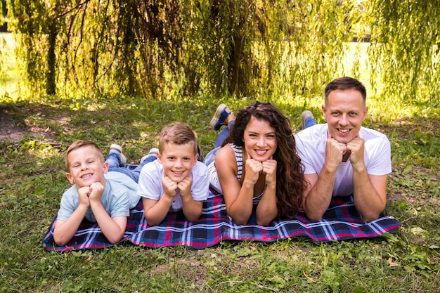 Photo gratuite famille posant sur une couverture de pique-nique