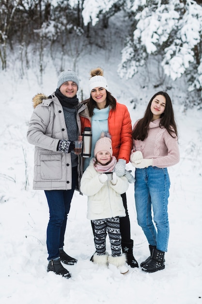 Famille posant sur fond d&#39;hiver