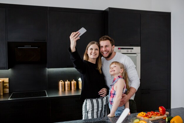 Famille prenant selfie dans la cuisine