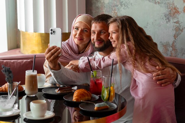 Famille prenant un selfie ensemble dans un restaurant