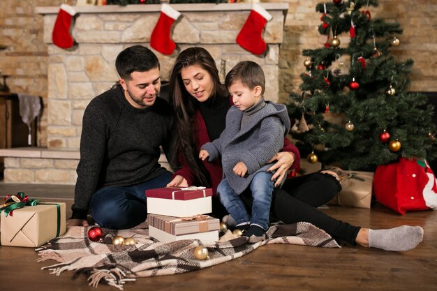 Famille près de la cheminée à Noël