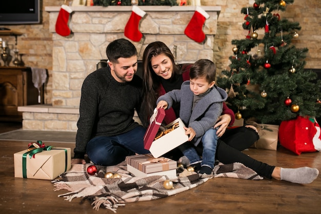 Famille près de la cheminée à Noël