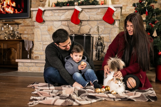 Famille près de la cheminée à Noël