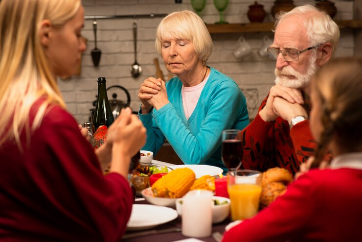 Photo gratuit famille priant à la table avec les yeux fermés