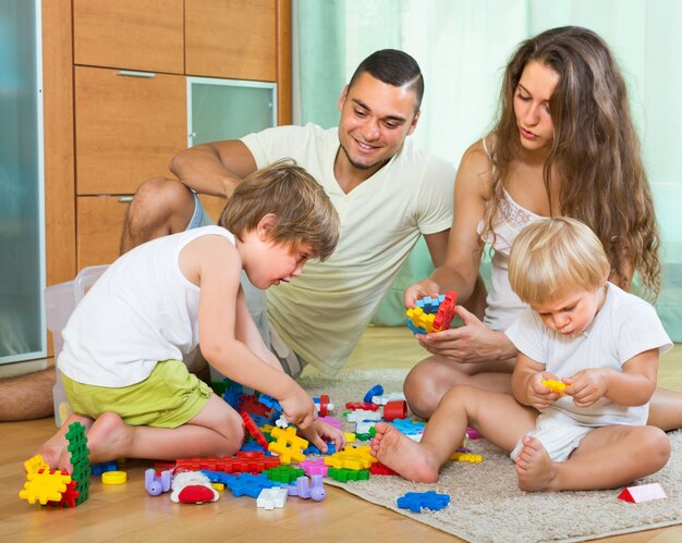 Famille de quatre à la maison avec des jouets