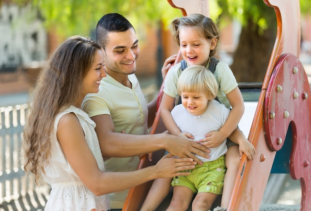 Famille de quatre personnes au terrain de jeux