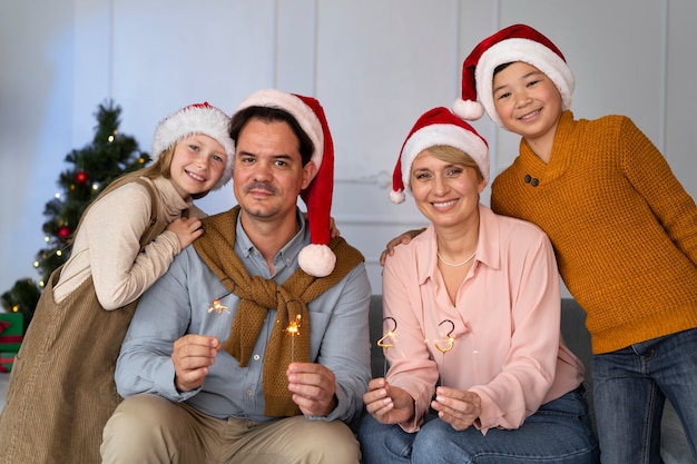 Famille de quatre personnes célébrant le nouvel an à la maison ensemble