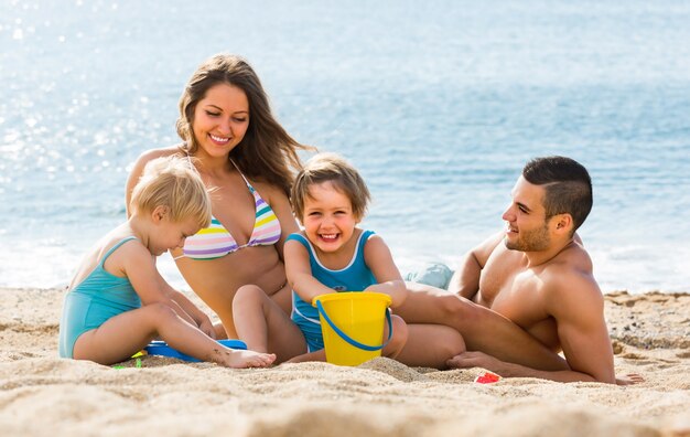 Famille de quatre personnes à la plage