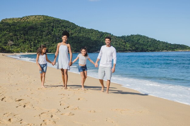 Famille qui marche sur la plage