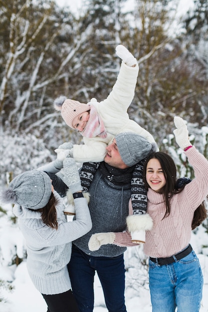 Photo gratuite famille s'amuser dans la forêt d'hiver