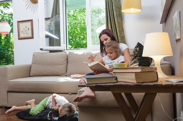 Famille se relaxant en lisant dans la chambre