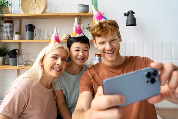 Famille souriante vue de face prenant selfie