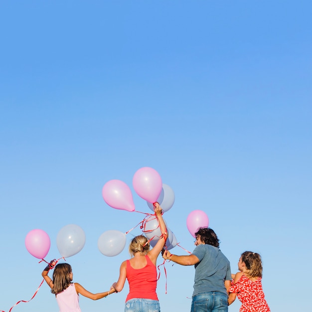 Famille tenant des ballons sur les têtes