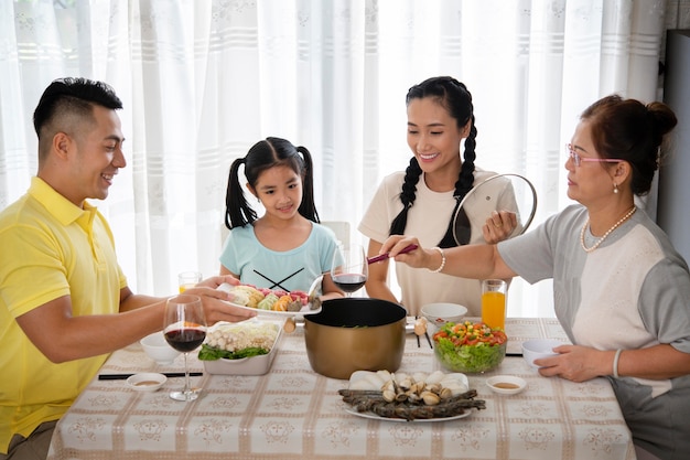 Photo gratuite famille de tir moyen assis à table