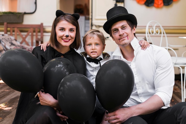 Photo gratuite famille de tir moyen avec des ballons noirs