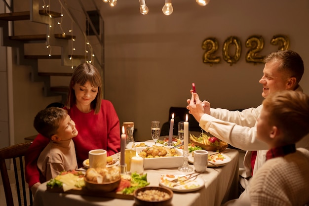 Photo gratuite famille vue de côté assis à table