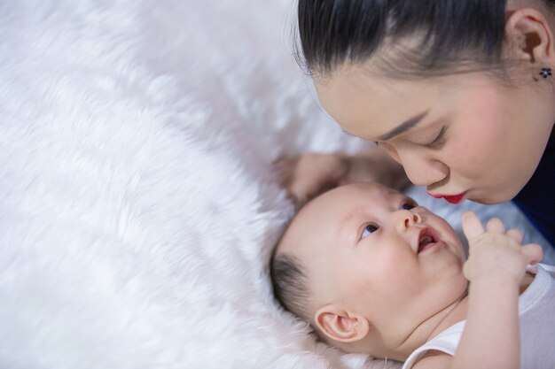 Les familles, les parents et les bébés sont allongés sur le lit dans le salon.