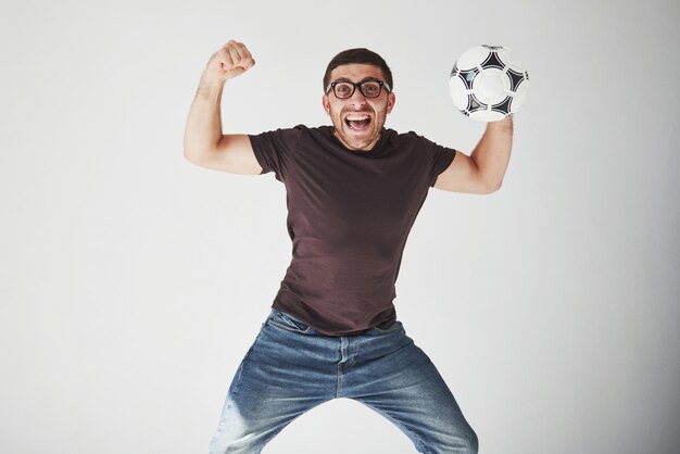 Fan de football excité avec un ballon de football isolé sur blanc