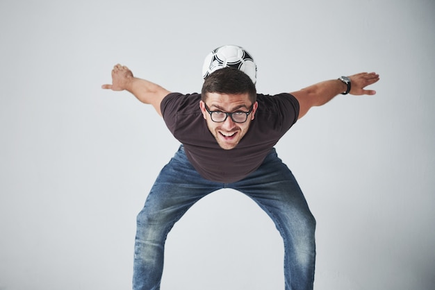 Fan de football excité avec un ballon de football isolé sur blanc