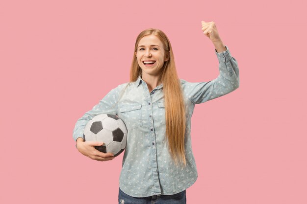 Fan sport woman player holding soccer ball isolé sur fond rose