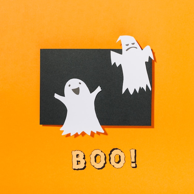 Des fantômes d&#39;Halloween sur un morceau de papier noir avec Boo! inscription ci-dessous