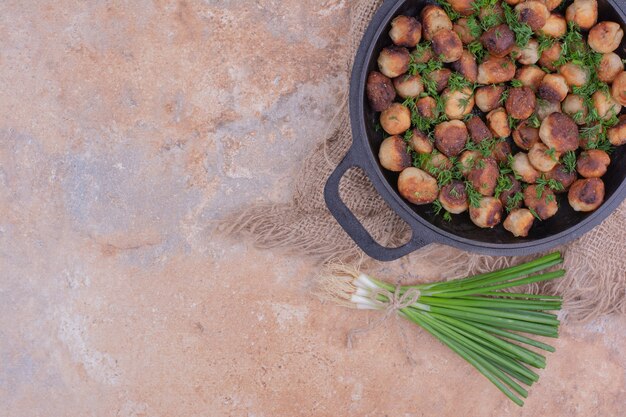 Farce à la viande grillée dans une poêle noire aux herbes