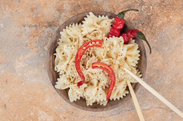 Farfalle au piment et épices dans un bol en bois.