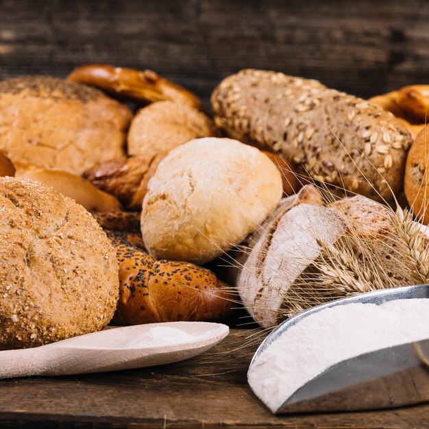 Farine avec des pains de grains entiers au four sur la table