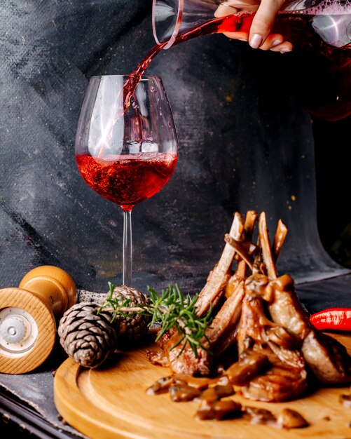 Farine de viande sur la surface en bois brune avec du vin rouge sur la surface grise