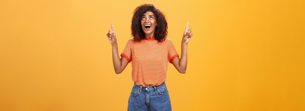 Fascinée impressionnée et amusée belle femme afro-américaine charmante avec une coiffure afro dans