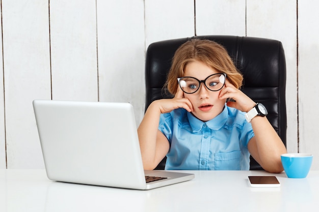 Fatigué de jeune belle fille assise au lieu de travail au bureau.