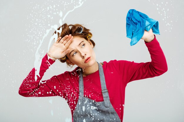 Fatigué de jeune femme fatiguée des tâches ménagères lors du nettoyage