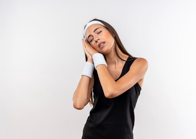 Fatigué de jeune fille assez sportive portant bandeau et bracelet gesticulant sommeil sur l'espace blanc