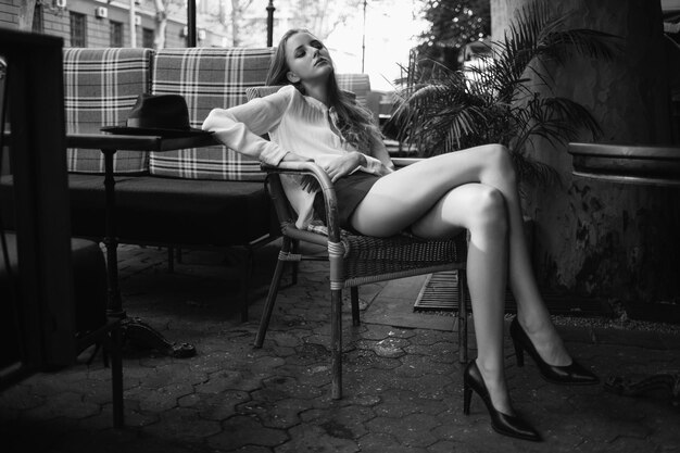 Fatigué jeune fille assise dans le café Belle femme avec des jambes sexy se reposer dans le restaurant Modèle assis dans un fauteuil dans un café français