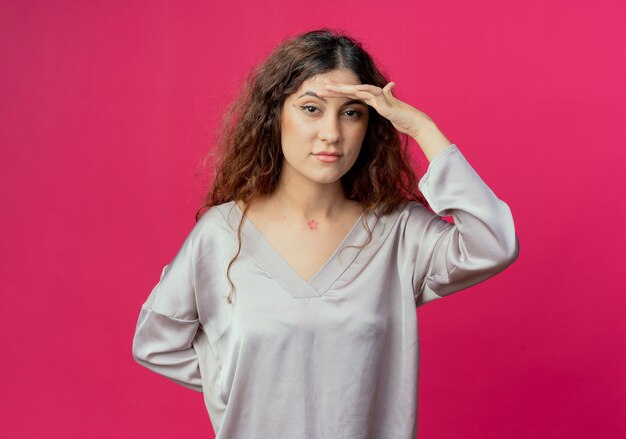 Fatigué de jeune jolie fille mettant la main sur le front isolé sur un mur rose