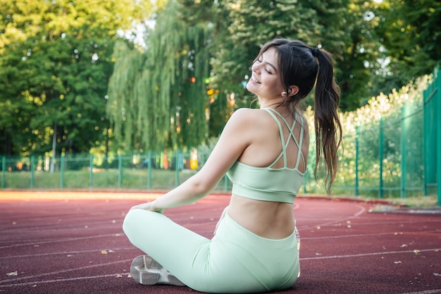 Photo gratuite fatigué jolie femme après avoir fait du jogging au stade