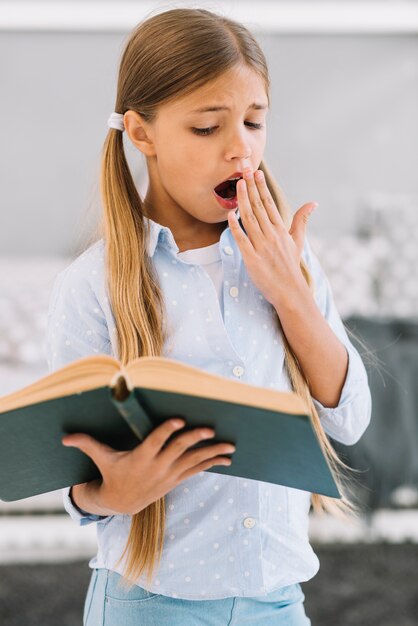 Fatigué jolie fille lisant un livre