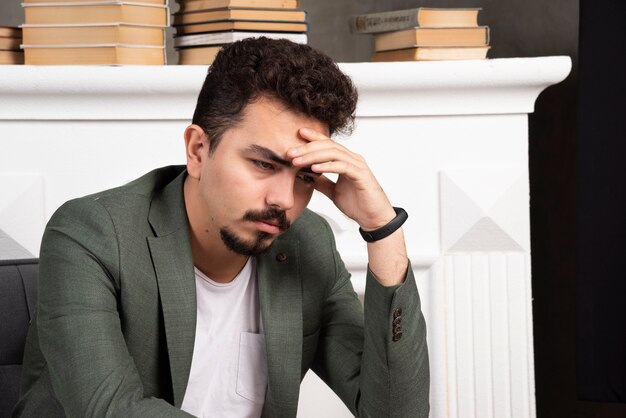 Fatigué et réfléchi. Jeune homme regardant vers le bas.