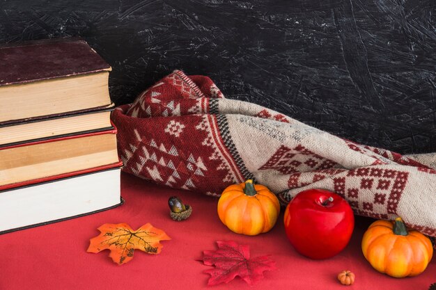 Faux fruits et couverture près des livres et des feuilles