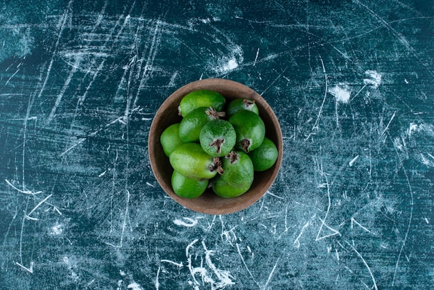 Feijoas Dans Une Tasse En Bois Sur Bleu.