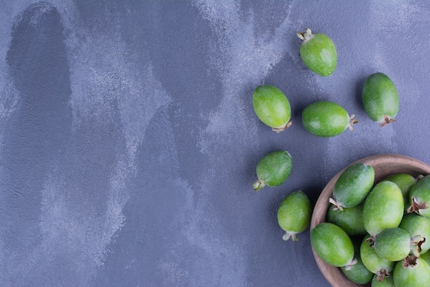 Photo gratuite feijoas verts dans une mini tasse sur bleu.