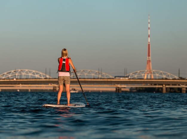 Femelle blonde sur paddleboard sur la rivière Daugava, Lettonie