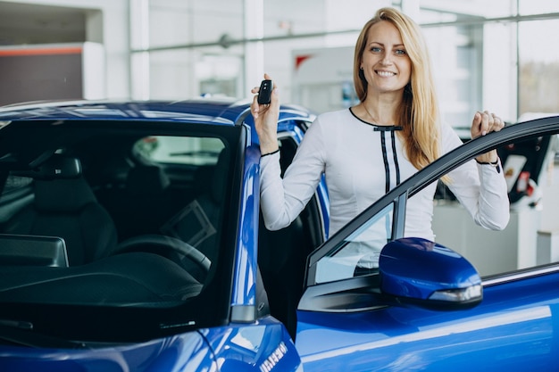 Femme achetant une nouvelle voiture dans un salon automobile